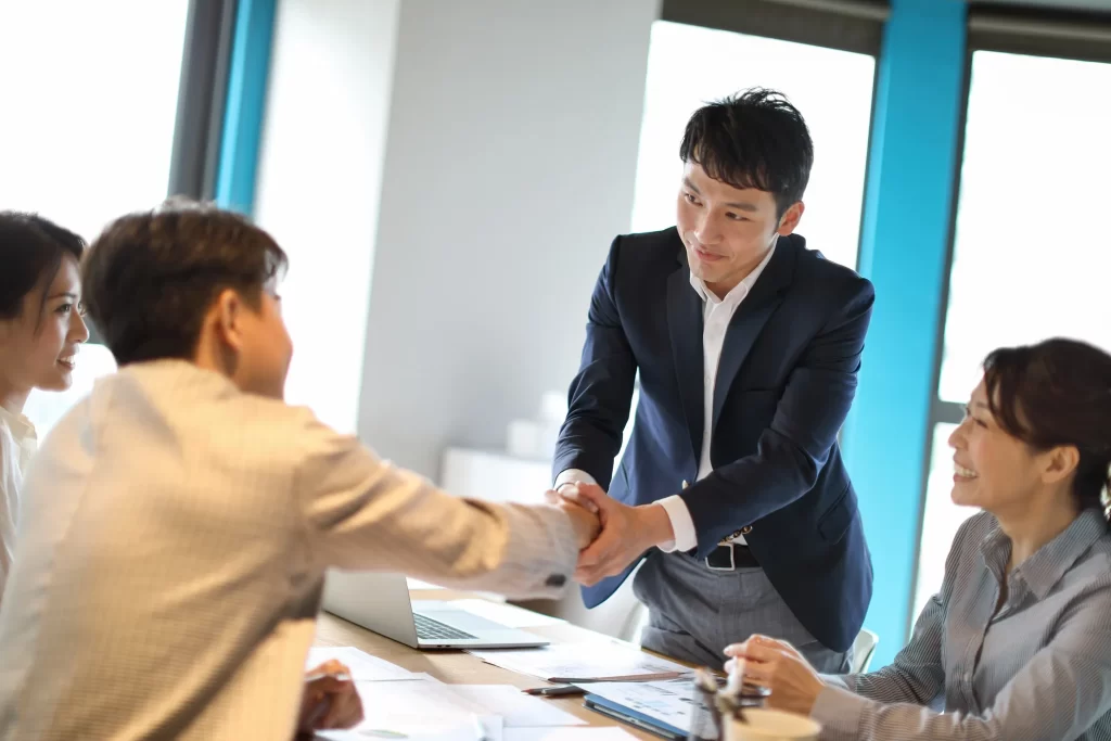 会議で意気投合し握手している